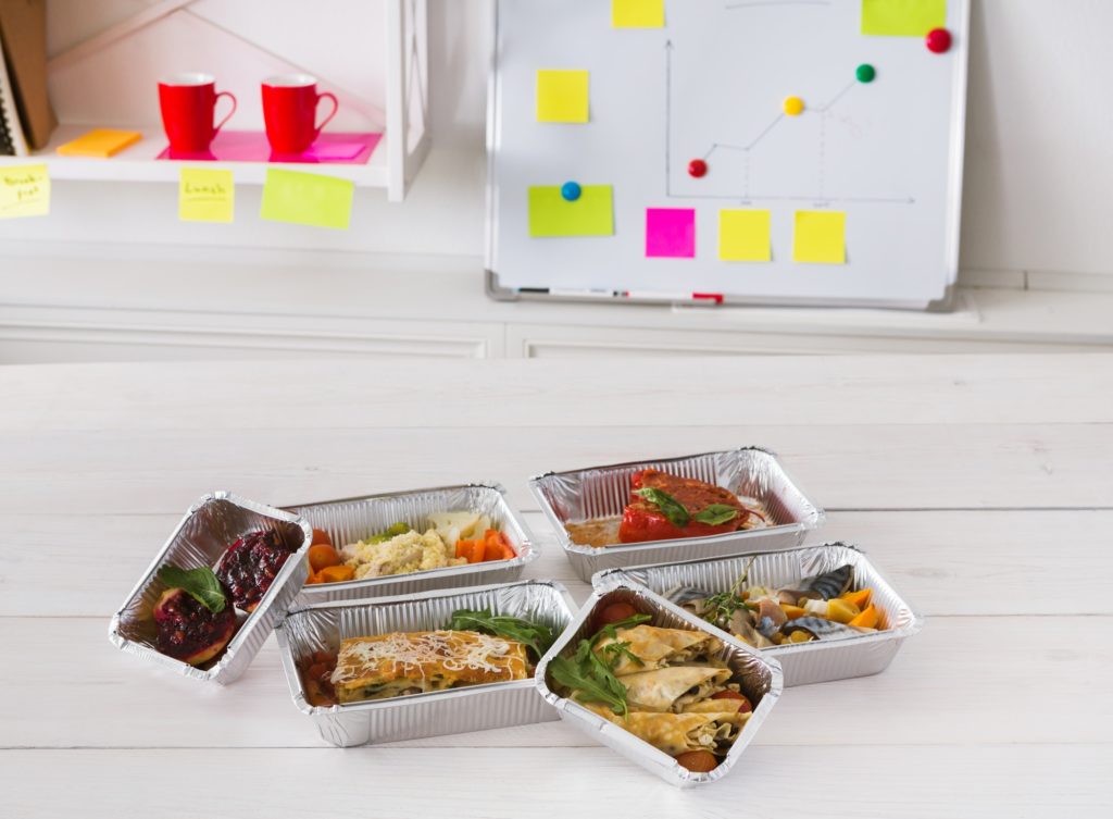 Healthy lunch foil box with diet food on office table